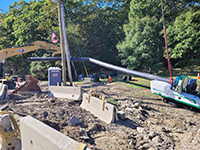 Distant view of bridge beams with trees in background.